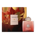 Amouage Guidance 46 perfume bottle and its matching outer packaging box. The bottle is a frosted pink glass with a metallic rose gold cap, and the box features an abstract red, gold, and brown pattern with a white label.